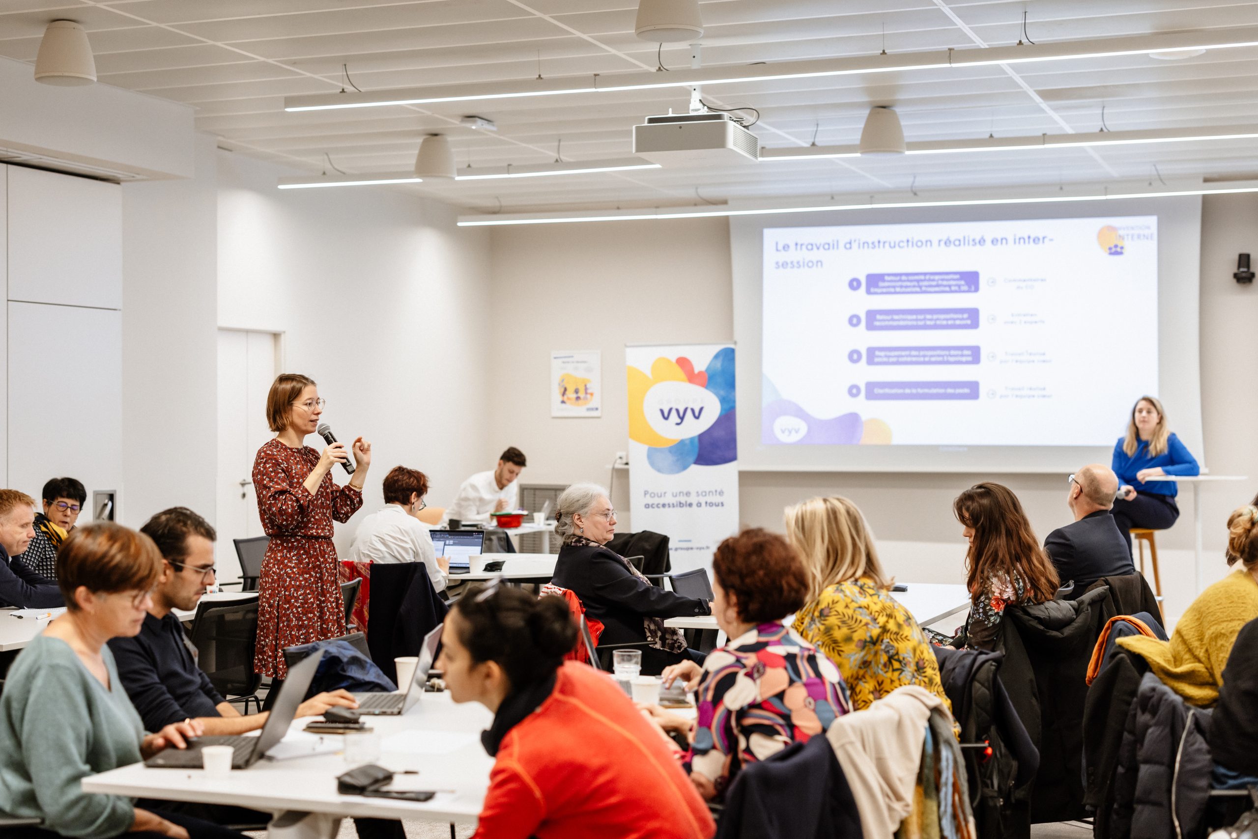 Une intervenante s’exprime au micro devant un groupe de collaborateurs du Groupe VYV réunis en atelier