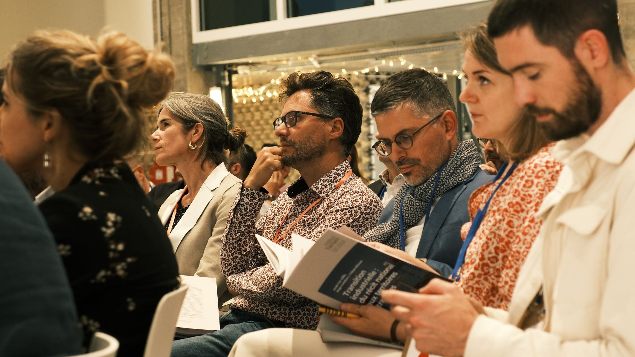 Participants à la restitution du livre blanc Engie, l'un feuilletant le document