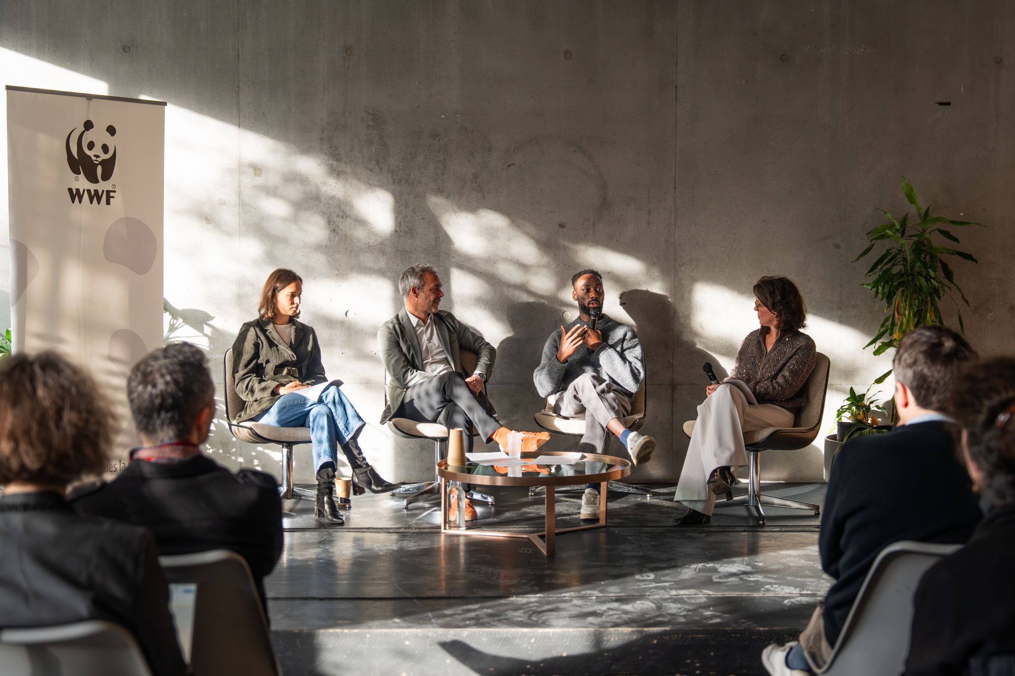 Panel de quatre intervenants en discussion devant un kakémono WWF, lors d’une table ronde sur les récits écologiques