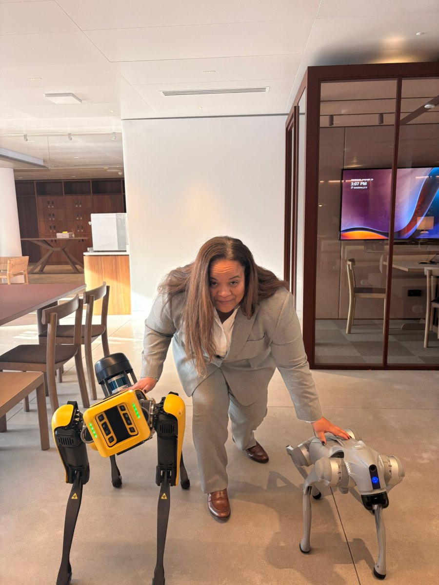 Une collaboratrice de bluenove avec deux robots quadrupèdes lors d’un événement